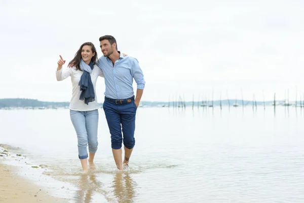 在海滩上散步的年轻夫妇 — 图库照片