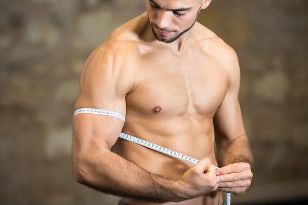 Muscular Jovem Fisiculturista Homem Medindo Bíceps Com Fita — Fotografia de Stock