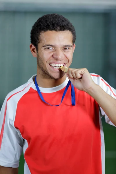 帅气的年轻男子运动员咬他的奖牌特写 — 图库照片