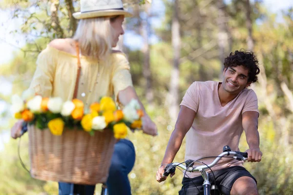 年轻人微笑着对夫妇骑自行车 — 图库照片