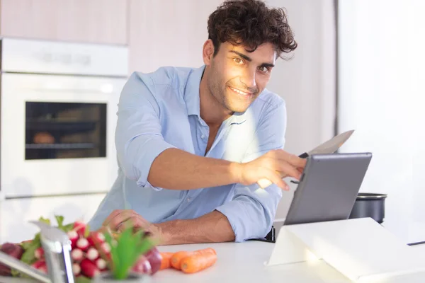 快乐的男人做饭和使用平板电脑 — 图库照片
