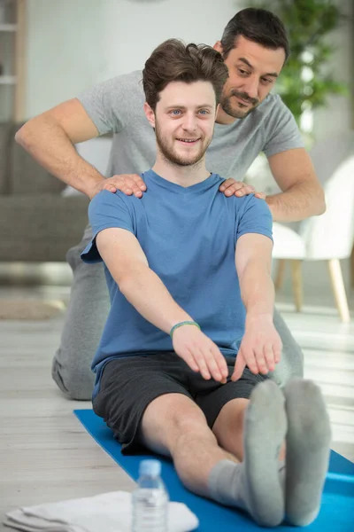 Personal Trainer Guiding Young Man Floor Exercises — Stock Photo, Image