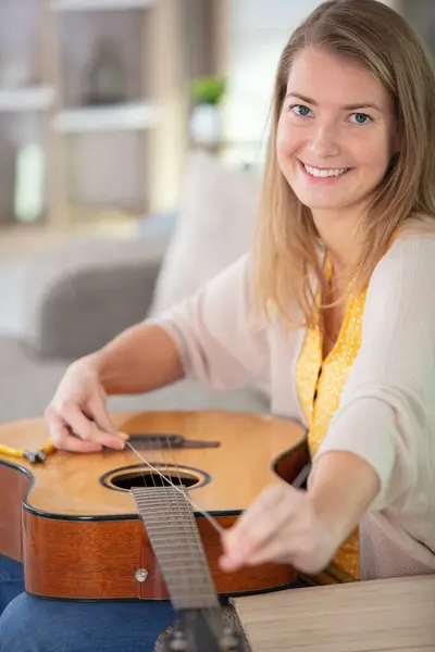 Joven Mujer Cambiando Cuerda Guitarra —  Fotos de Stock