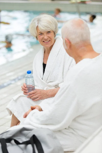 Senior Couple Bathrobes Sat Resting Pool — Stock Photo, Image