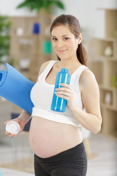 Schöne Schwangere Frau Mit Trainingsmatte Und Wasser — Stockfoto