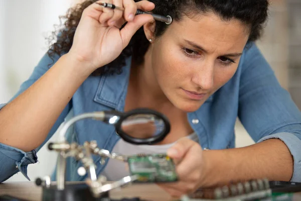 若い女性が携帯電話の修理店を修理し — ストック写真