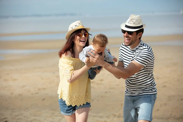带着孩子在海滩上散步的家庭 — 图库照片