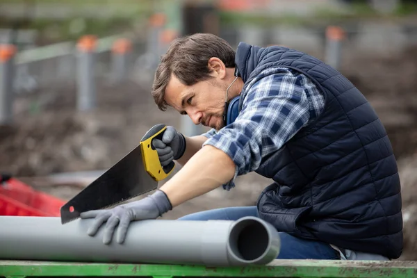 Trabajador Masculino Está Cortando Tubo Pvc Con Una Sierra — Foto de Stock