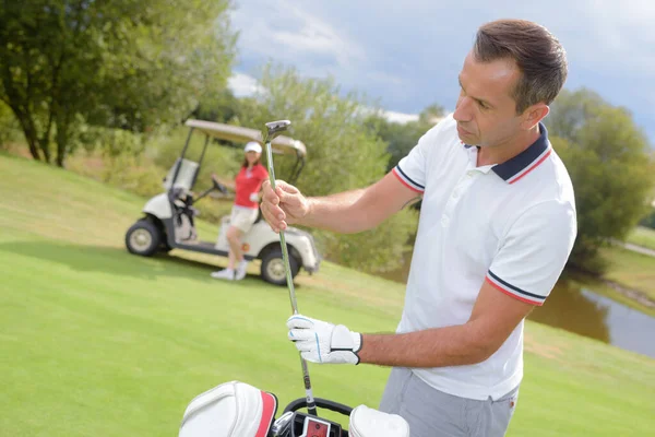 Golfer Wählt Golfschläger Auf Grün Mit Frau — Stockfoto