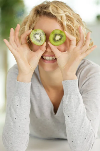 Young Woman Covering Her Eyes Kiwi Slices — Fotografia de Stock