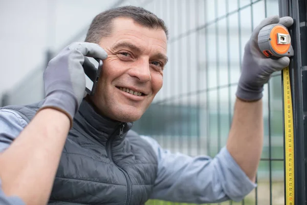 Ευτυχισμένος Άντρας Στο Τηλέφωνο Μετράει Τον Φράχτη — Φωτογραφία Αρχείου