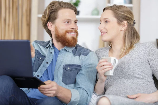Glückliches Junges Paar Mit Kaffeetassen Mit Laptop Auf Sofa — Stockfoto