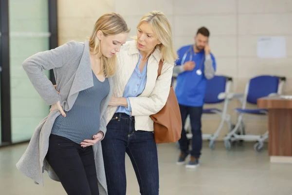 妊娠中の女性と母親が病院の廊下で — ストック写真