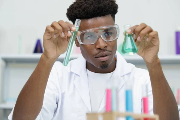 Young Male Lab Worker Holding Flasks — Stock Photo, Image
