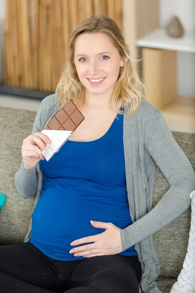 Büyük Bir Çikolata Çubuğu Tutan Hamile Bir Kadın — Stok fotoğraf