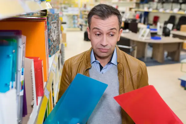Człowiek Wybierając Foldery Supermarkecie — Zdjęcie stockowe