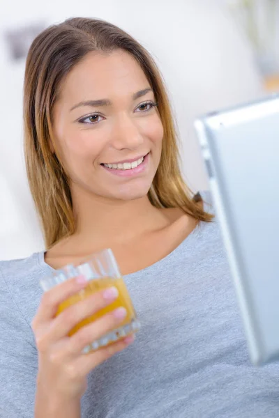 Genç Bayan Tablete Bakıyor Elinde Meyve Suyu Bardağı Tutuyor — Stok fotoğraf