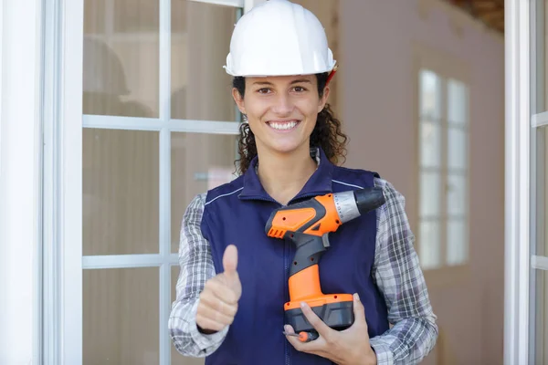 Female Builder Holding Cordless Drill Making Thumbs Gesture — Stock Photo, Image