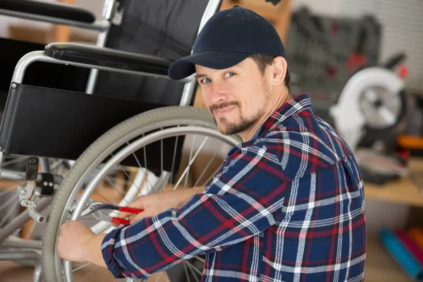 Mann Bedient Mit Zange Die Bremsen Eines Rollstuhls — Stockfoto