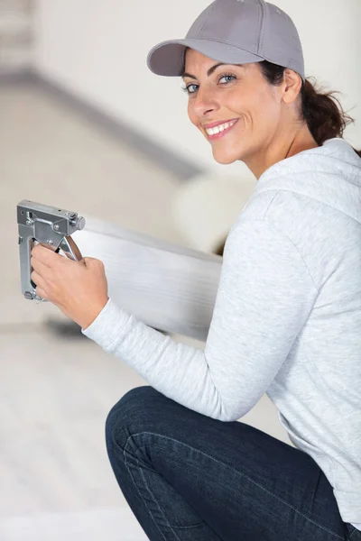幸せな若い女性測定し ラミネートの床をマーキング — ストック写真