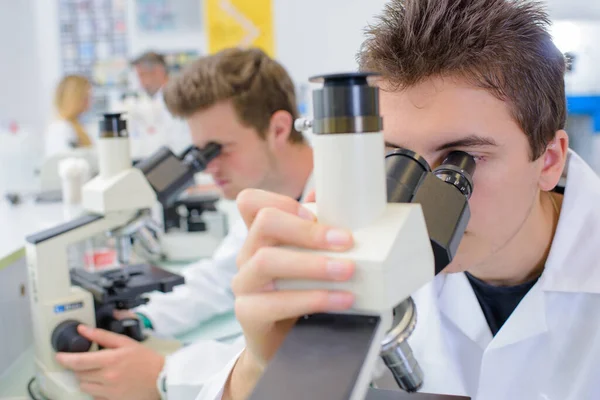 Młody Człowiek Patrząc Mikroskop — Zdjęcie stockowe