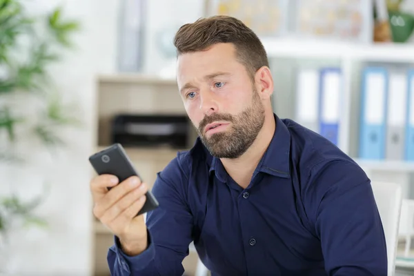 Людина Використовує Телефон Сидячи Столом Сучасному Офісі — стокове фото