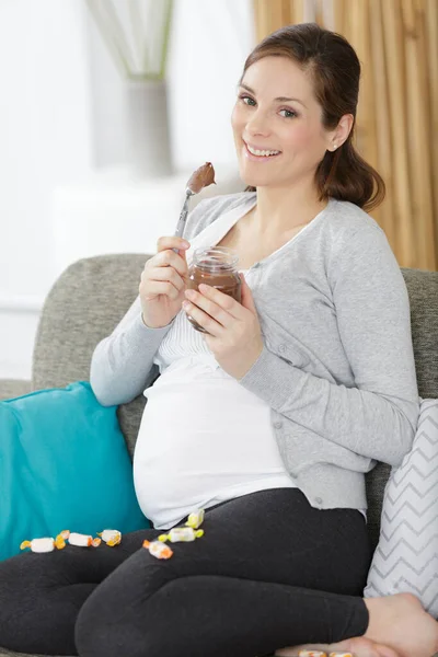 妊娠中の若い女性がチョコレートを食べて — ストック写真