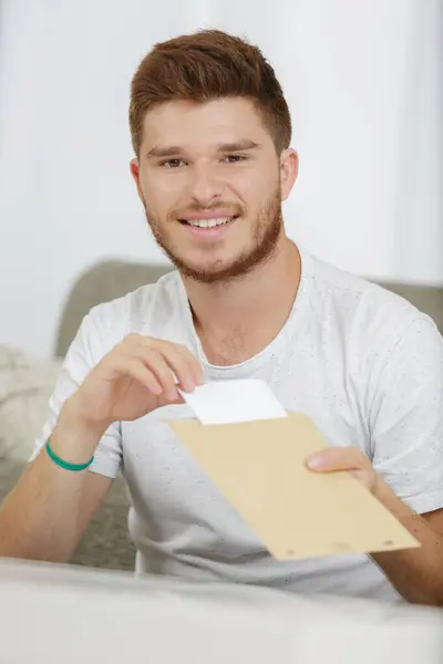 Jonge Man Neemt Brief Van Enveloppe — Stockfoto