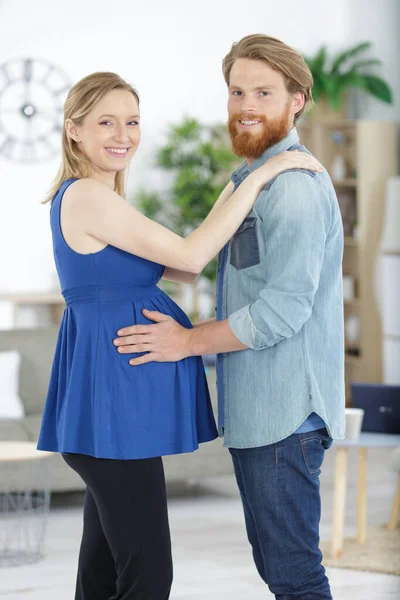 幸せな男は妊娠中の妻を抱きかかえて — ストック写真
