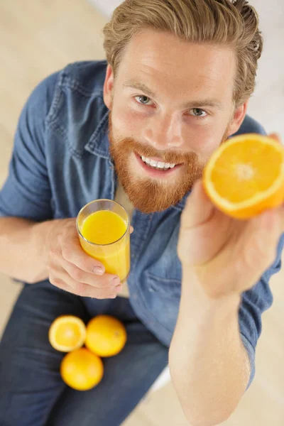 Uomo Alla Ricerca Fotocamera Mostrando Tropicale Bio Frutta Arancione — Foto Stock