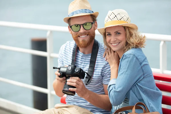 在海边的年轻夫妇拿着相机 — 图库照片