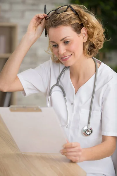 女性医師はクリップボードで処方箋を読んでいます — ストック写真