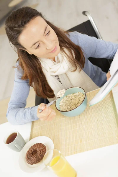 Handicapped Female Eating Cereal Reading — Stock Photo, Image