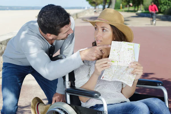 Niepełnosprawna Kobieta Rozmawia Mężczyzną Wskazując Mapę — Zdjęcie stockowe