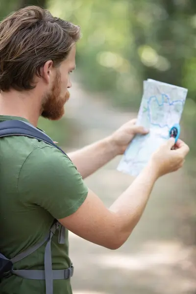 Νεαρό Όμορφος Πεζοπόρος Χρησιμοποιώντας Χάρτη Και Την Πυξίδα Μέσα Στη — Φωτογραφία Αρχείου