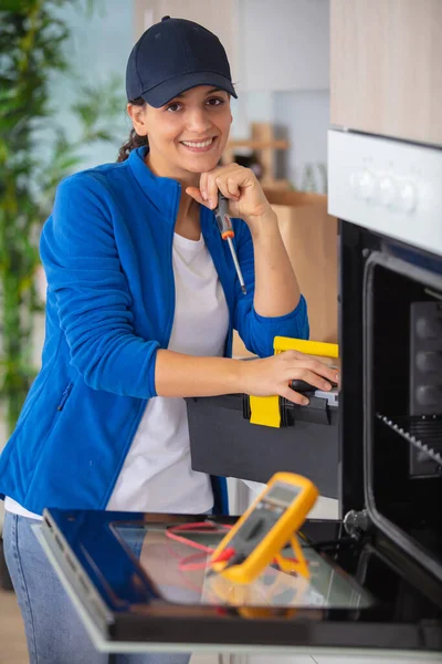 Een Glimlachende Mooie Vrouw Repareren Van Een Kleine Oven — Stockfoto