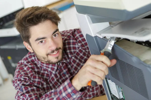 兴高采烈的年轻人修理打印机 — 图库照片