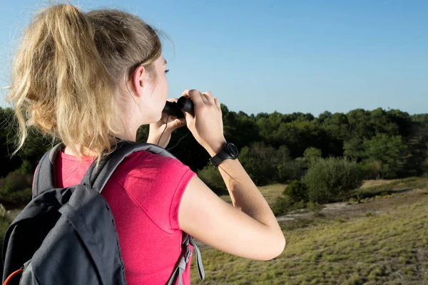 戴双筒望远镜的女徒步旅行者欣赏风景 — 图库照片