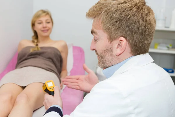 医生在女性病人腿上使用激光装置 — 图库照片