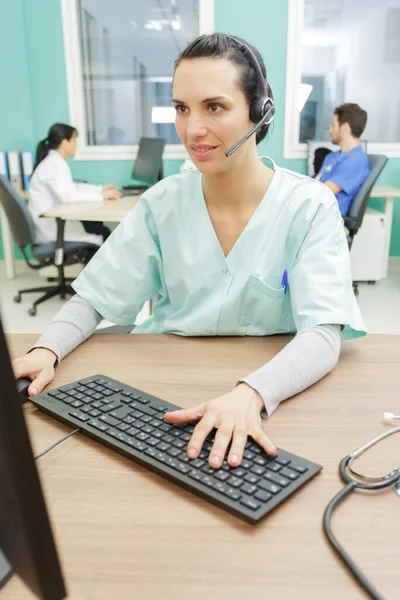 在计算机上从事秘书工作的女医务人员 — 图库照片