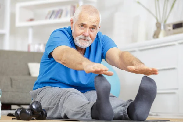 Joyful Senior Stretching His Legs Home — Stock fotografie