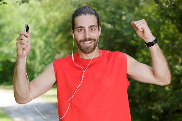 精力充沛的男人戴着耳机锻炼和听音乐 — 图库照片