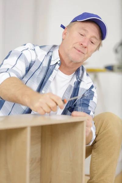 Älterer Mann Baut Möbel Neuem Haus Zusammen — Stockfoto