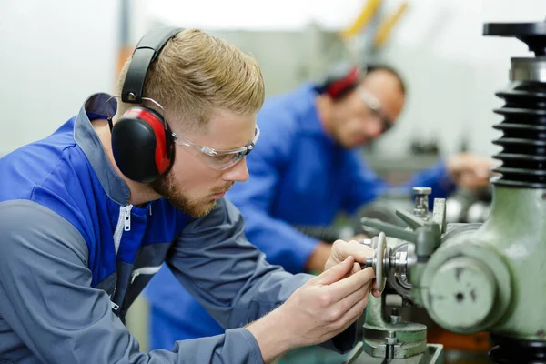 Ingenieure Die Mit Fabrikmaschinen Arbeiten Und Ohrenschützer Tragen — Stockfoto