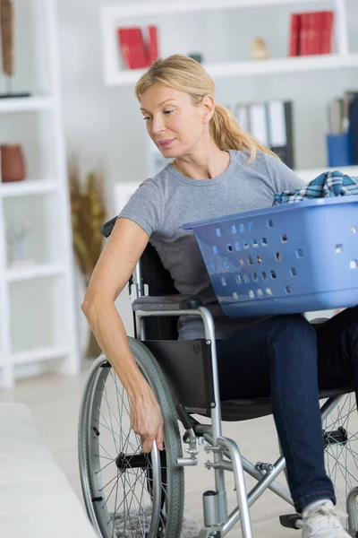 轮椅上的妈妈在找更多的脏衣服 — 图库照片