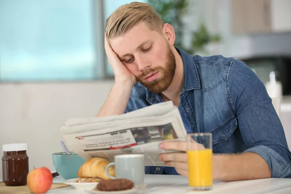 Gelangweilter Mann Liest Beim Frühstück Nachrichten Vor — Stockfoto