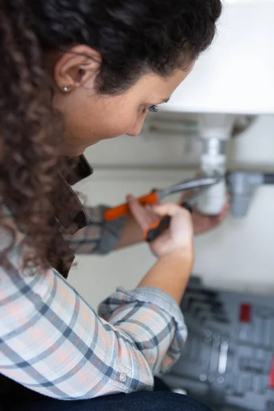 Eine Frau Repariert Küchenspüle — Stockfoto