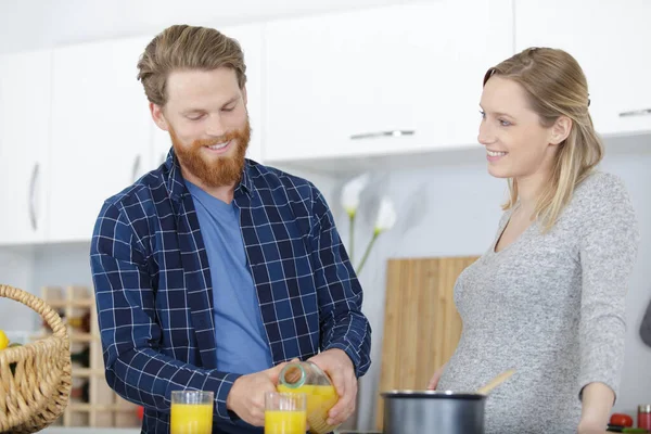 Man Gieten Sinaasappelsap Voor Zijn Zwangere Vrouw — Stockfoto
