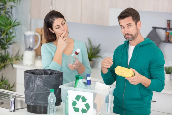 若いカップルが彼らの台所でプラスチックのリサイクル — ストック写真