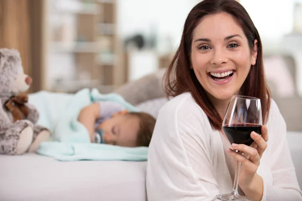 Jovem Mãe Segura Copo Vinho Enquanto Bebê Dorme — Fotografia de Stock